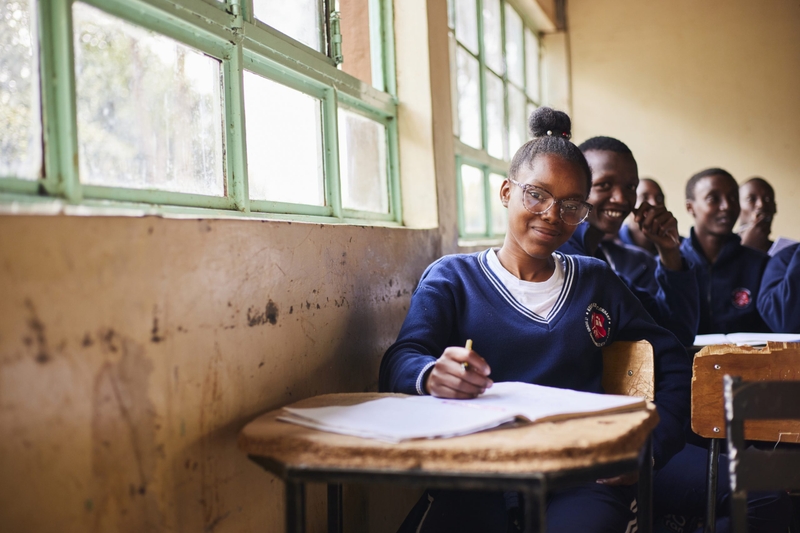 Elever som sitter vid sina bänkar i ett klassrum.